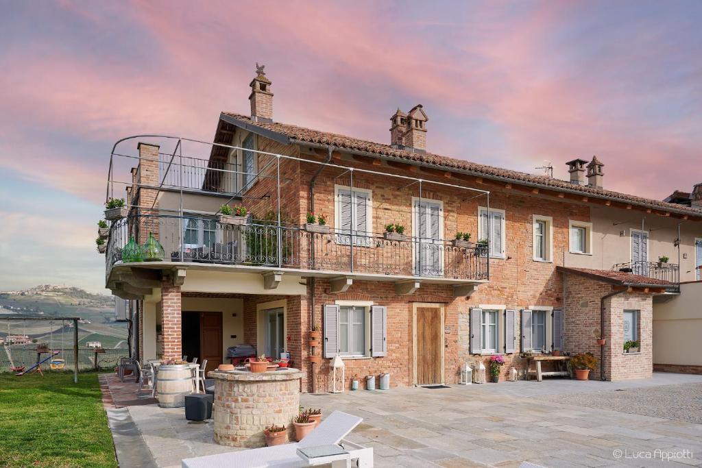 a large brick house with a balcony on top of it at Agriturismo Cascina Sciulun in Monforte dʼAlba