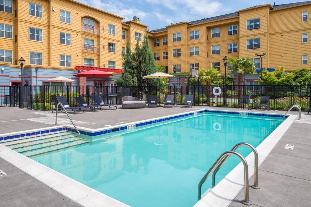 basen z krzesłami i budynek w obiekcie Residence Inn by Marriott Portland North w mieście Portland