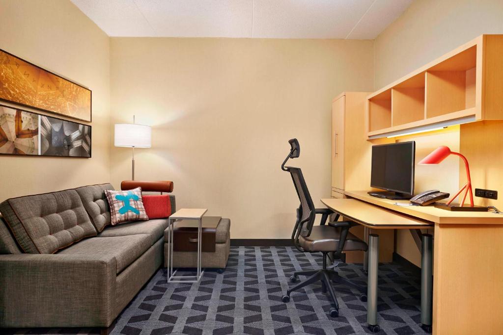 a living room with a couch and a desk with a computer at TownePlace Suites by Marriott London in London