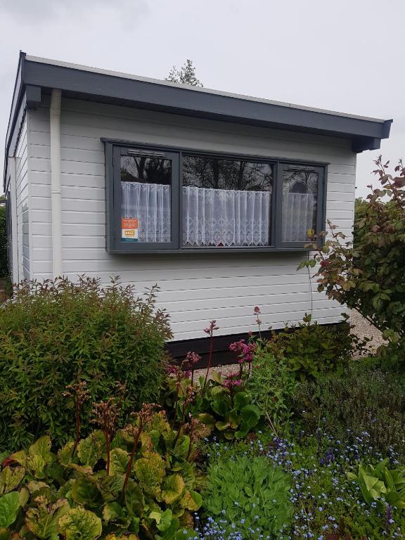 a house with a window with curtains in it at Beach Resort Kamperland - 771 in Kamperland