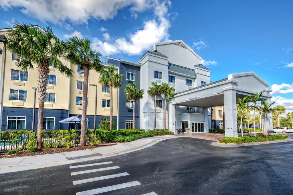 a building with palm trees in front of a street at Fairfield Inn and Suites by Marriott Naples in Naples
