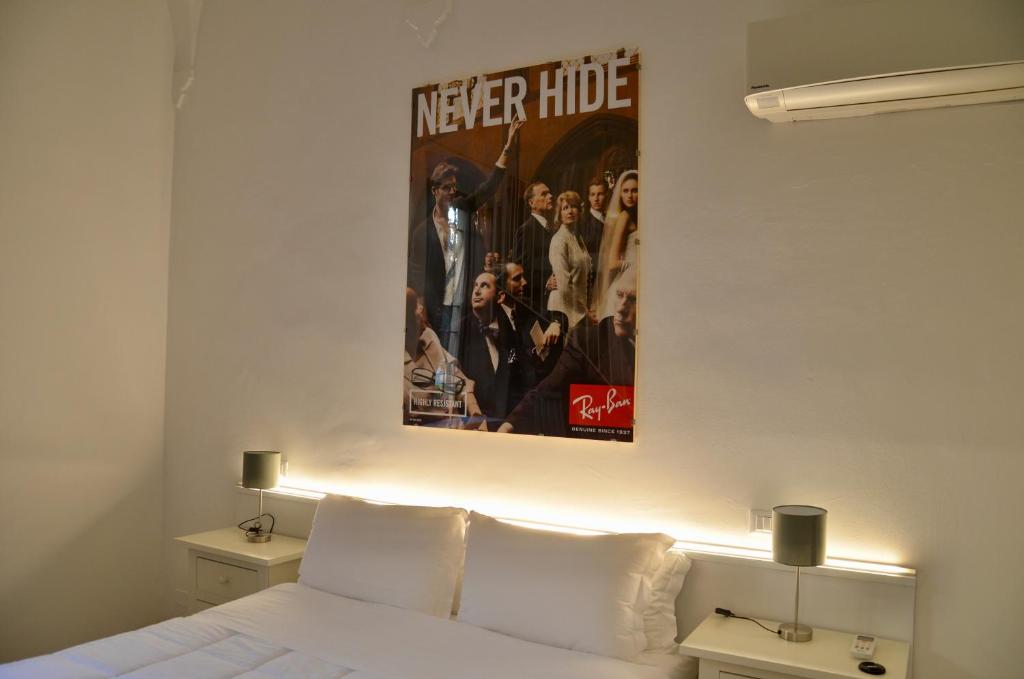 a poster of a movie hanging above a bed at DUOMO26 BOUTIQUE APARTMENT in Desenzano del Garda
