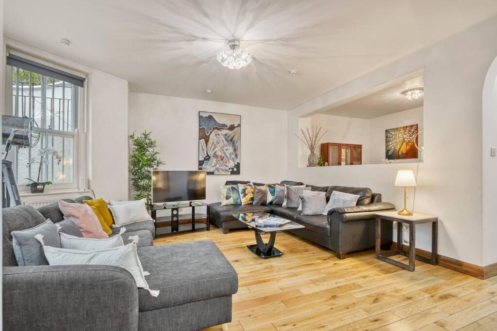 uma sala de estar com dois sofás e uma televisão em Spacious 3 bed Apt- Earls Court em Londres