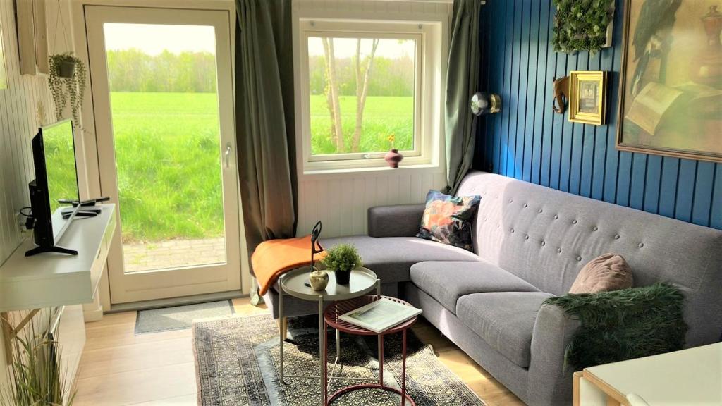 een woonkamer met een bank en een raam bij Hytten - Tiny house in Grenå