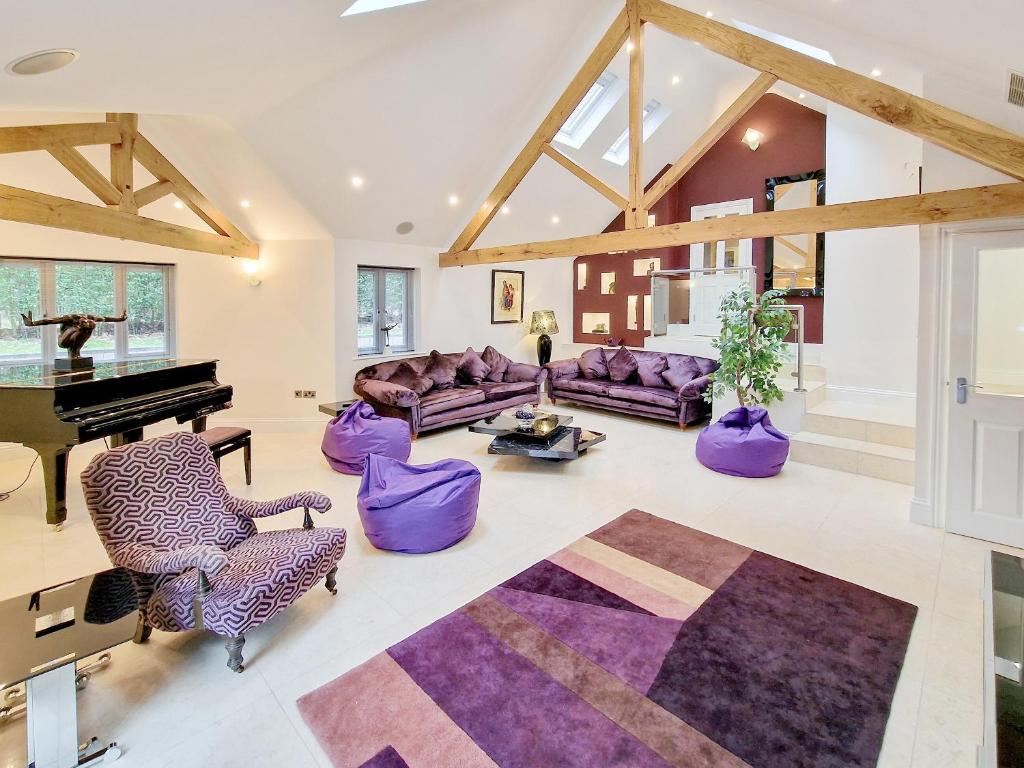 sala de estar con muebles de color púrpura y piano en The Lodge en Skipwith