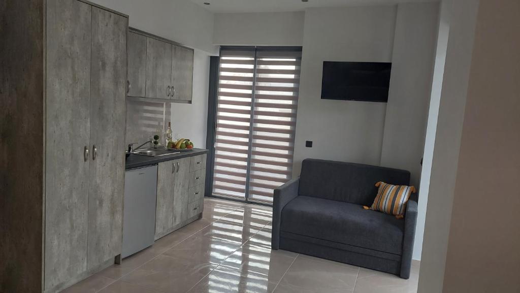 a kitchen with a blue chair and a sink at Luana Monte Apartments in Amoudara Herakliou