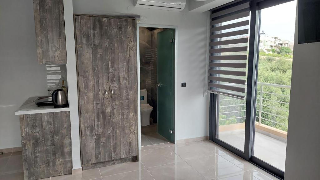 a room with a sliding door with a window at Luana Monte Apartments in Amoudara Herakliou