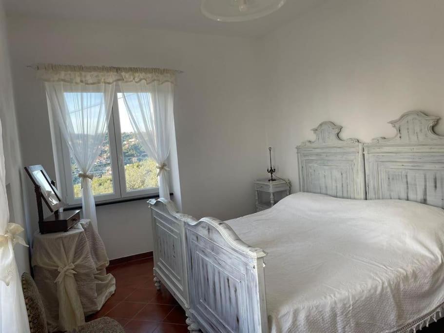 een witte slaapkamer met een wit bed en een raam bij Ca' Bianca in San Bartolomeo