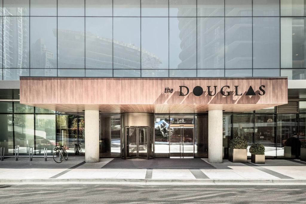 um edifício de vidro com um sinal que lê a duquesa em the DOUGLAS, Autograph Collection em Vancouver