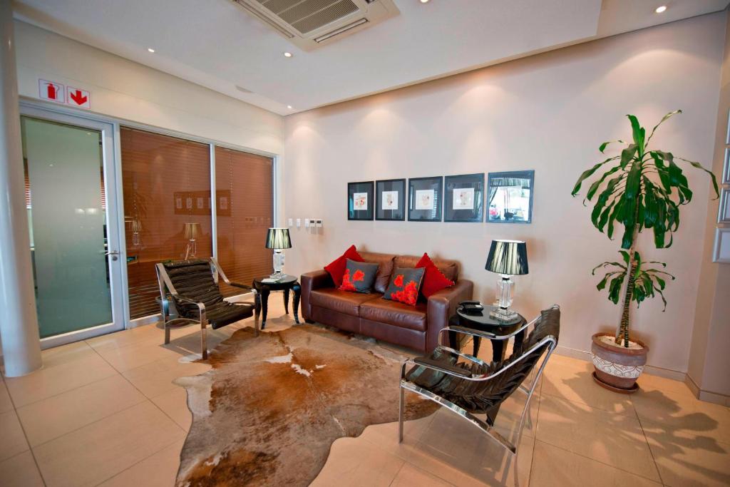 a living room with a couch and a table at Protea Hotel by Marriott Windhoek Furstenhof in Windhoek