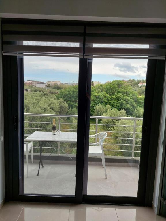 a view of a balcony with a table and a window at Luana Monte Apartments in Amoudara Herakliou