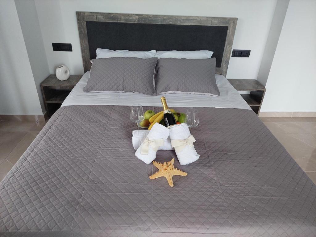 a bed with a table with wine glasses and a starfish at Luana Monte Apartments in Amoudara Herakliou