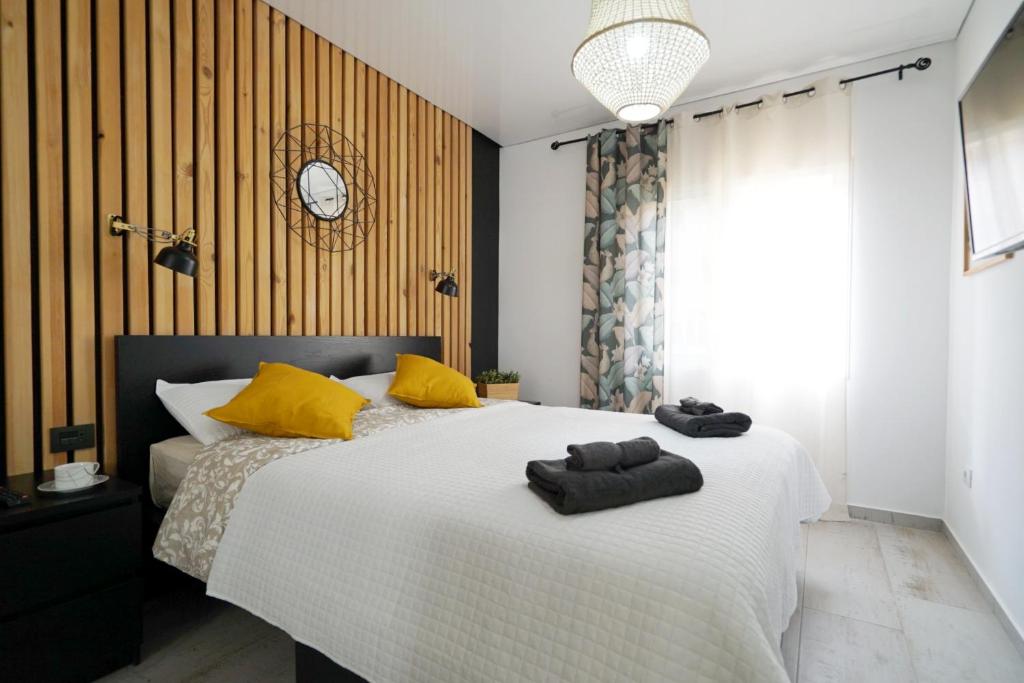 1 dormitorio con 1 cama grande con almohadas amarillas en Apartment in central Los Cristianos, en Los Cristianos