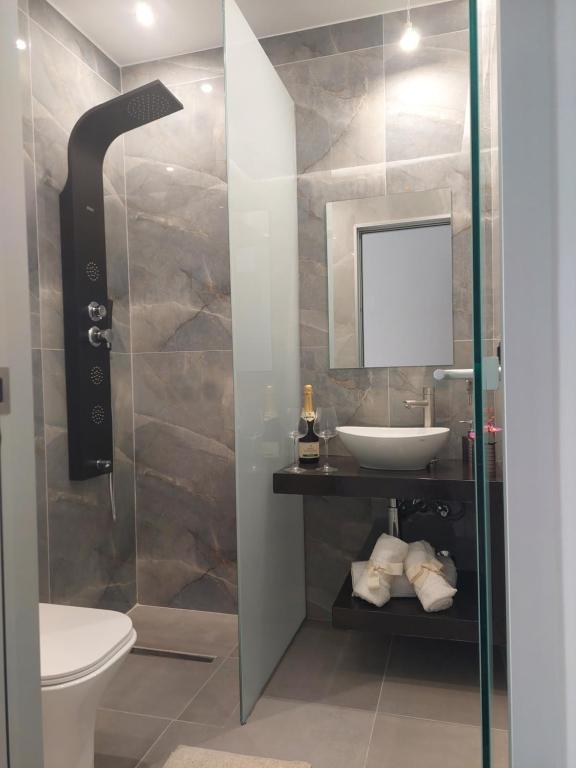 a bathroom with a sink and a toilet and a mirror at Luana Monte Apartments in Amoudara Herakliou