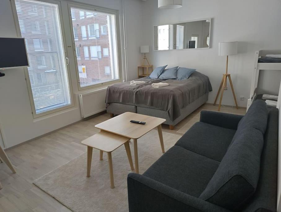 een slaapkamer met een bed, een bank en een tafel bij New apparment, near of Airport, in Tikkurila in Vantaa