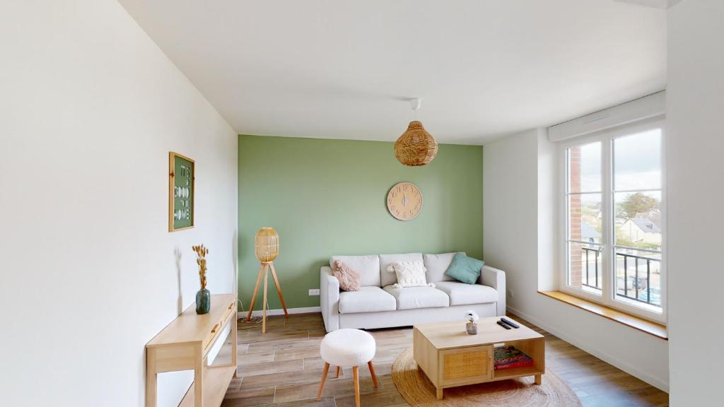 un salon avec un canapé et une table dans l'établissement Appartement Les Sables d’Or, à Barneville-Carteret