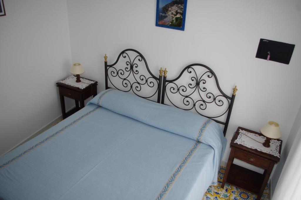 a bedroom with a bed with a blue blanket at Casa Fortunata in Positano