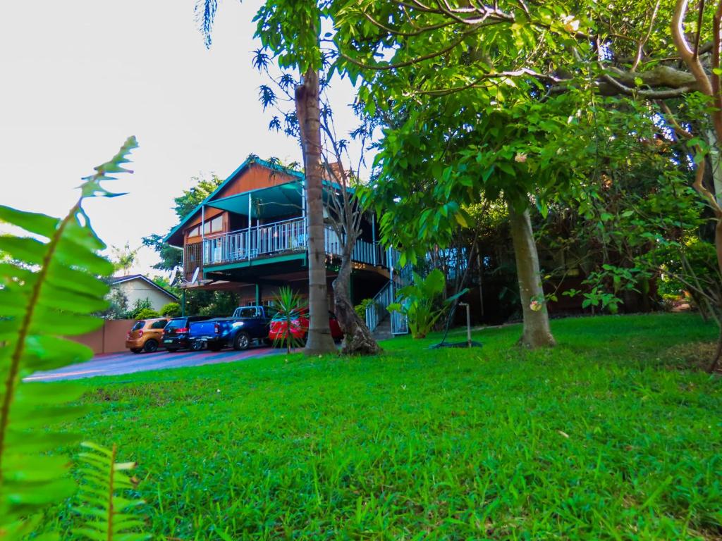 a house with a porch and a yard with trees at Homeinn Guesthouse in Nelspruit