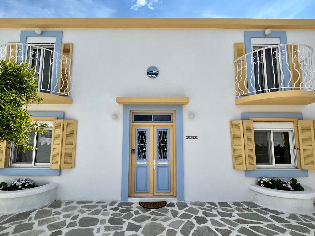 a white house with yellow windows and a door at Casa Piaduli in Faliraki