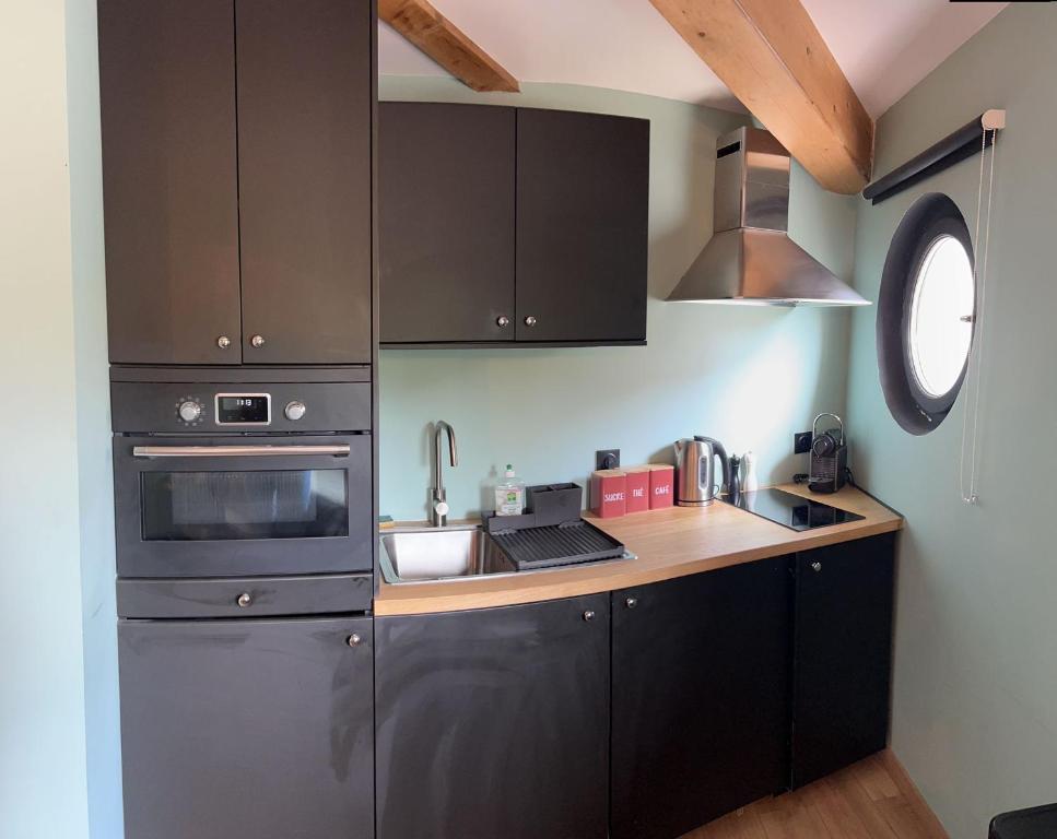 a kitchen with stainless steel appliances and a window at Le petit clocher de Cassis in Cassis