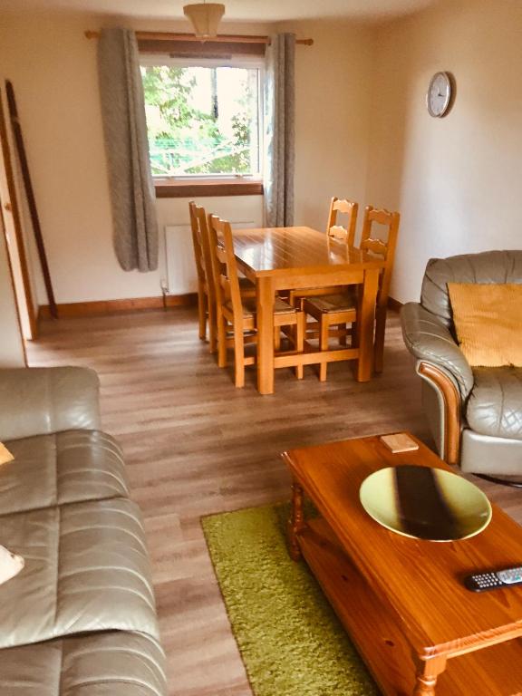 a living room with a table and a dining room at Invermac House in Inverness