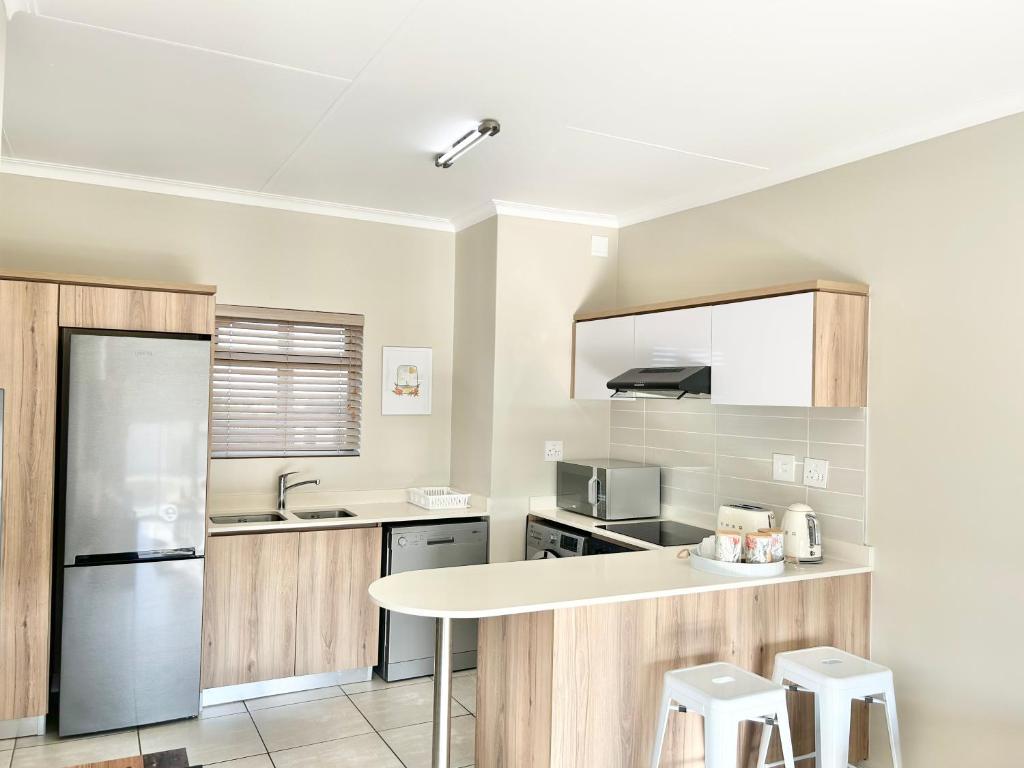 a kitchen with wooden cabinets and a white counter top at Ballito Hills - Ocean View, Queen Bed & Free Wi-Fi in Durban