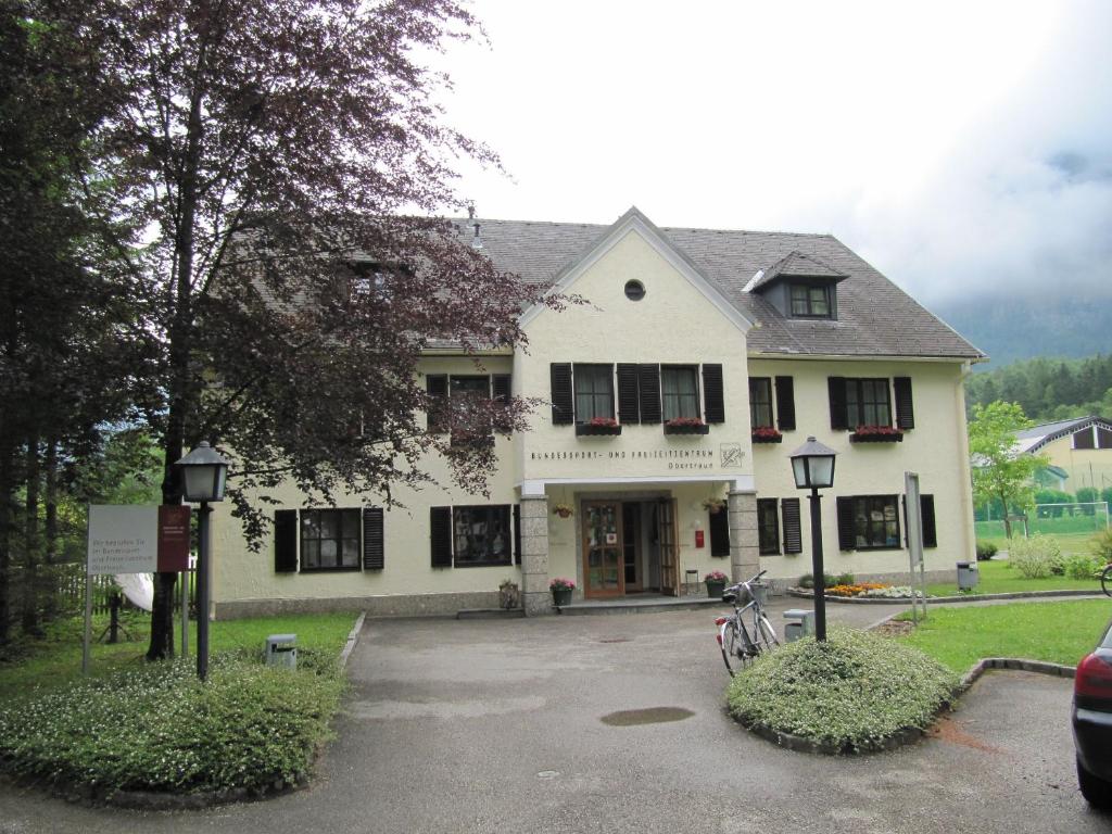 una casa blanca con bicicletas estacionadas frente a ella en Austrian Sports Resort, BSFZ Obertraun en Obertraun