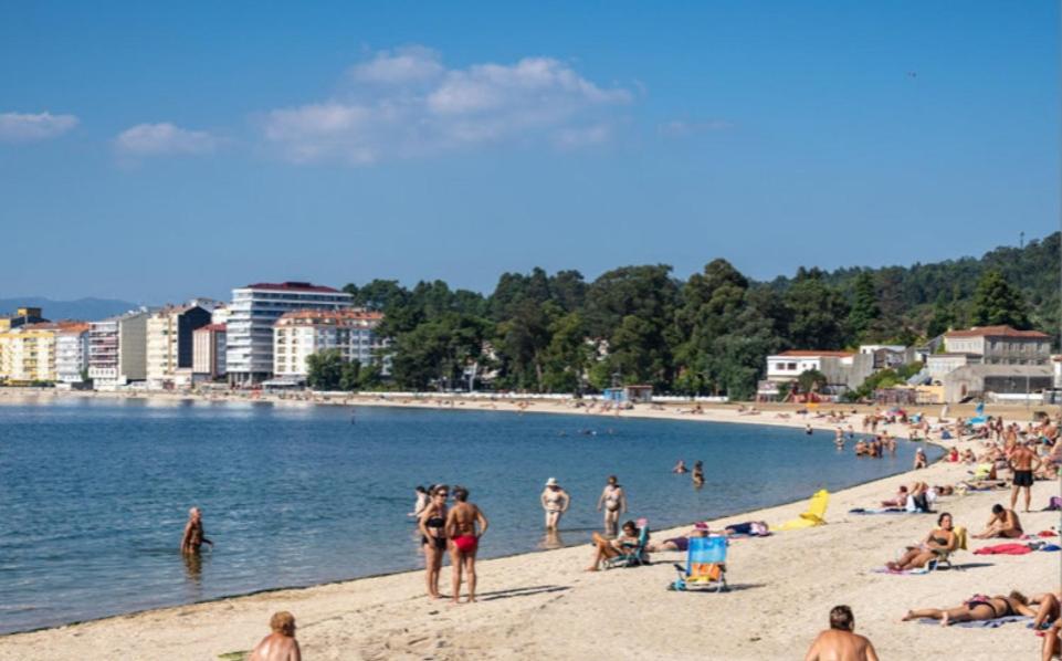 eine Gruppe von Menschen am Strand im Wasser in der Unterkunft Apto Cortegada in Vilagarcia de Arousa