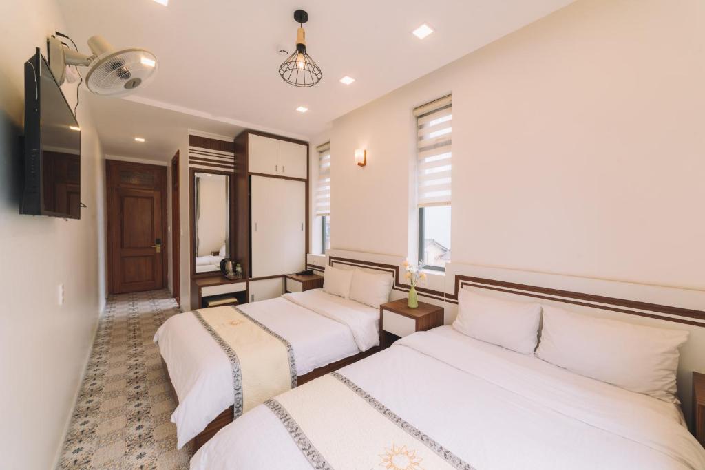 Postel nebo postele na pokoji v ubytování Hạ Na Hotel Đà Lạt