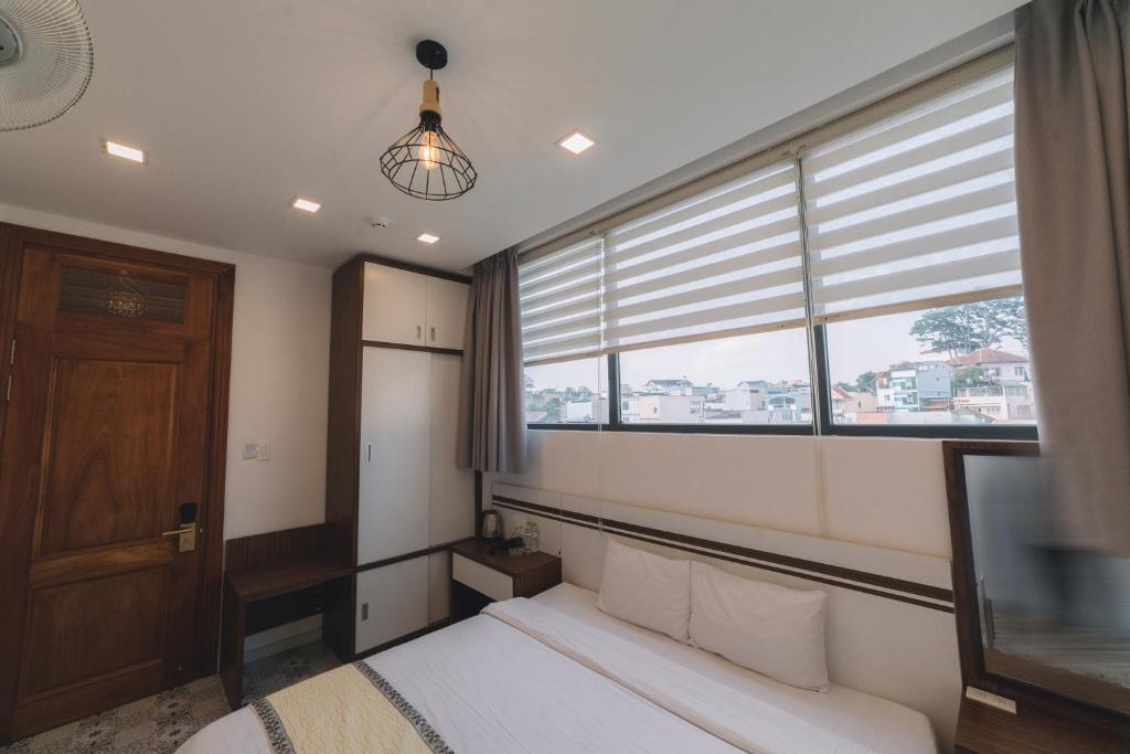 Postel nebo postele na pokoji v ubytování Hạ Na Hotel Đà Lạt