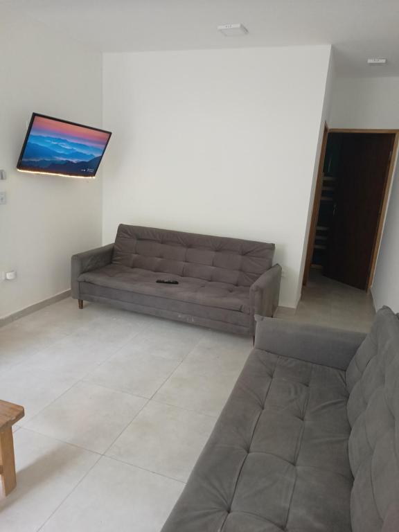 a living room with a couch and a flat screen tv at #Pousada São Paulo SP ótima localização in Sao Paulo
