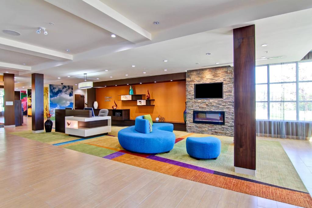 a living room with blue chairs and a fireplace at Fairfield Inn & Suites by Marriott Kamloops in Kamloops