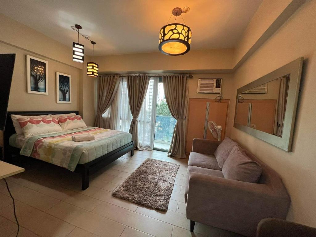 a bedroom with a bed and a couch at NAIA Condo Palm Tree 2 in Manila