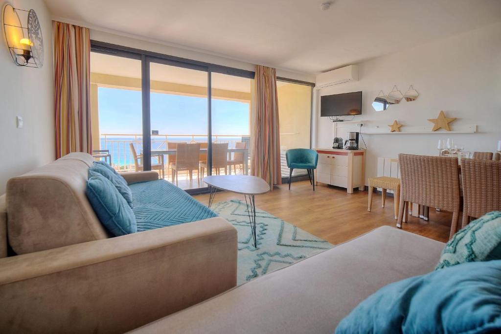 un salon avec un canapé et une salle à manger dans l'établissement IMMOGROOM - sea view - Pool - Terrace - Parking - Wifi - AC, à Cannes
