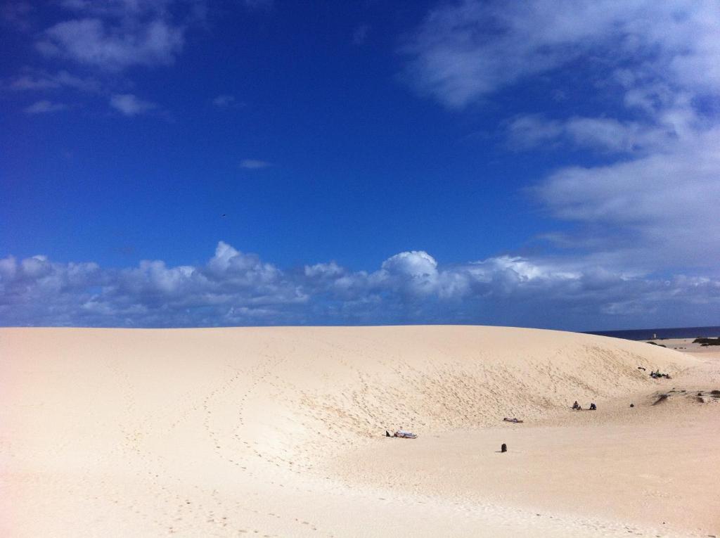 una gran duna de arena bajo un cielo azul con nubes en Casa Ayla Montecastillo A8, en Caleta de Fuste