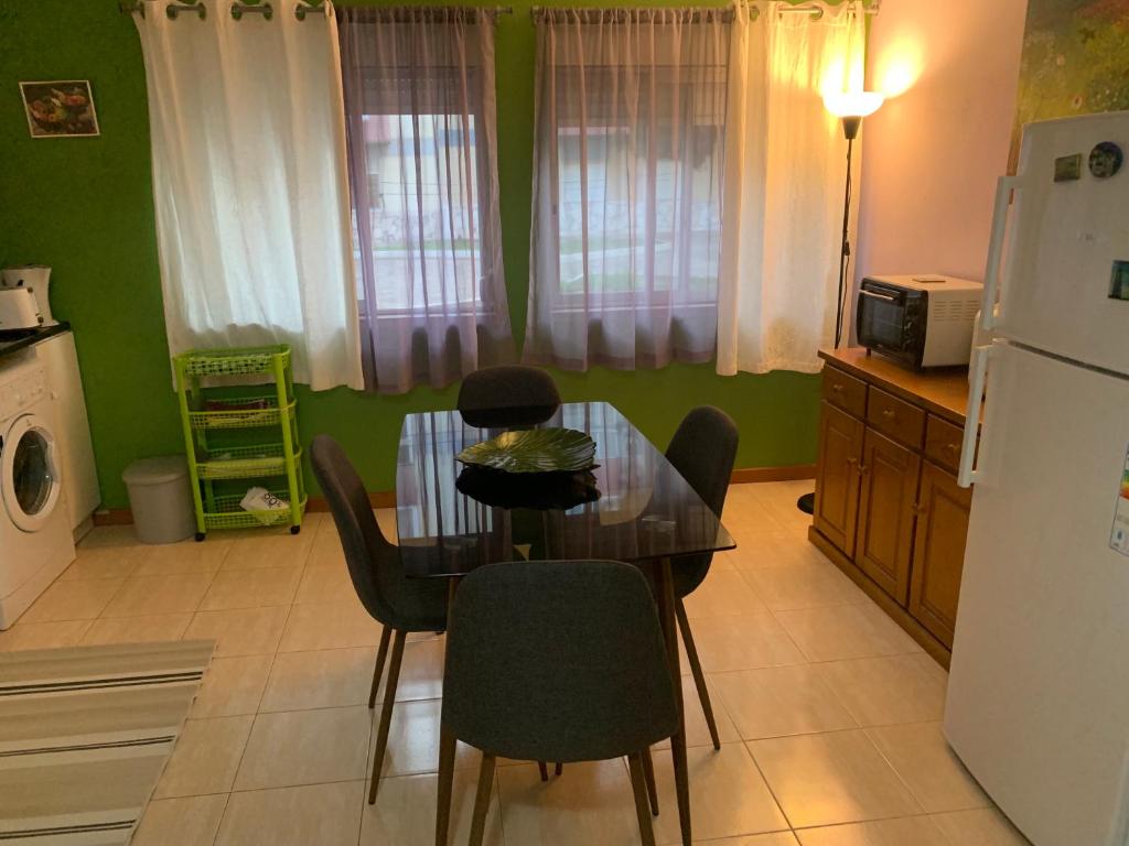 uma cozinha com uma mesa e cadeiras e um frigorífico em Charming T1 apartment in Seixal em Aldeia de Paio Pires