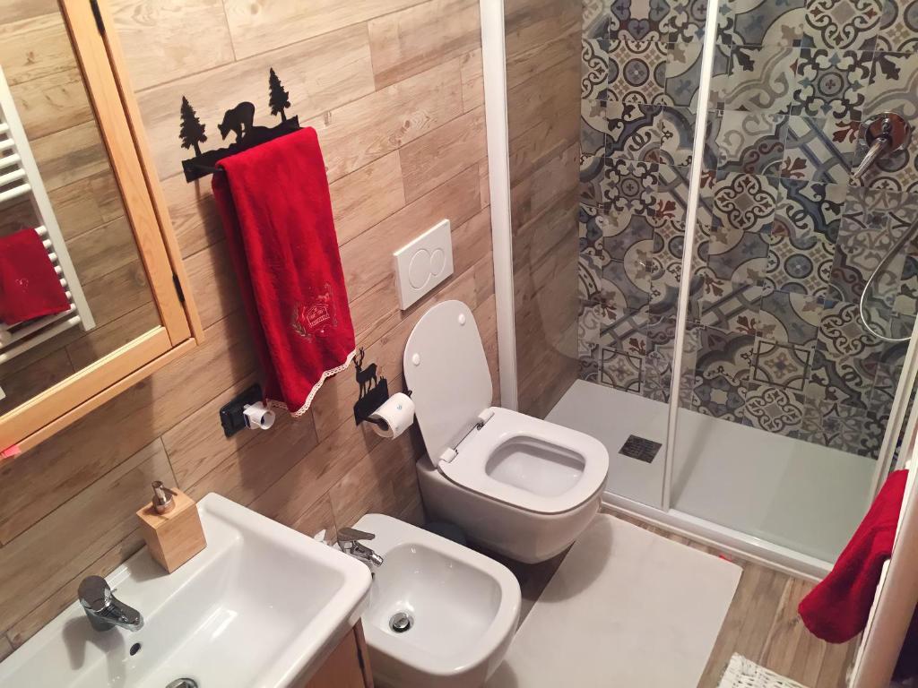 a bathroom with a toilet and a sink and a shower at Casetta dei Cuori - Alpine Style Cozy Apartment in Folgarida