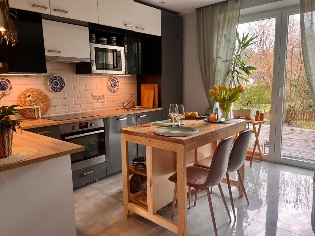 a kitchen with a wooden table with two chairs at Apartament Leszczyna in Olsztyn