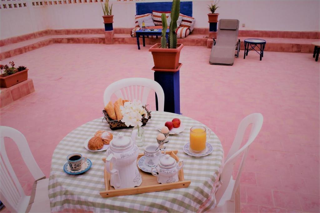 a table with breakfast foods and orange juice on it at Asunfou : Appartement d'apaisement in Mirleft