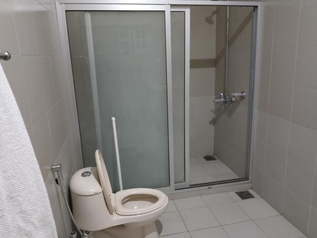 a bathroom with a toilet with a glass shower at Bourbon Bliss guest house in Rawalpindi