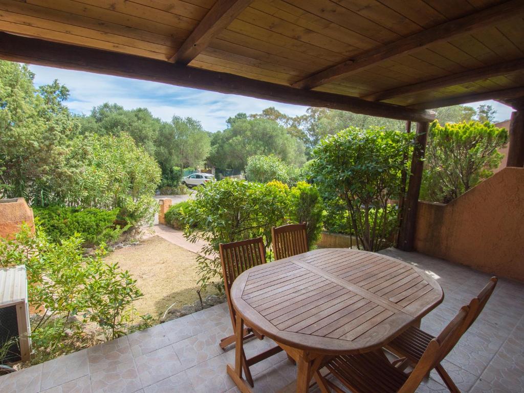 a wooden table and chairs on a patio at Appartamento Santa Maria Porto Pollo in Palau