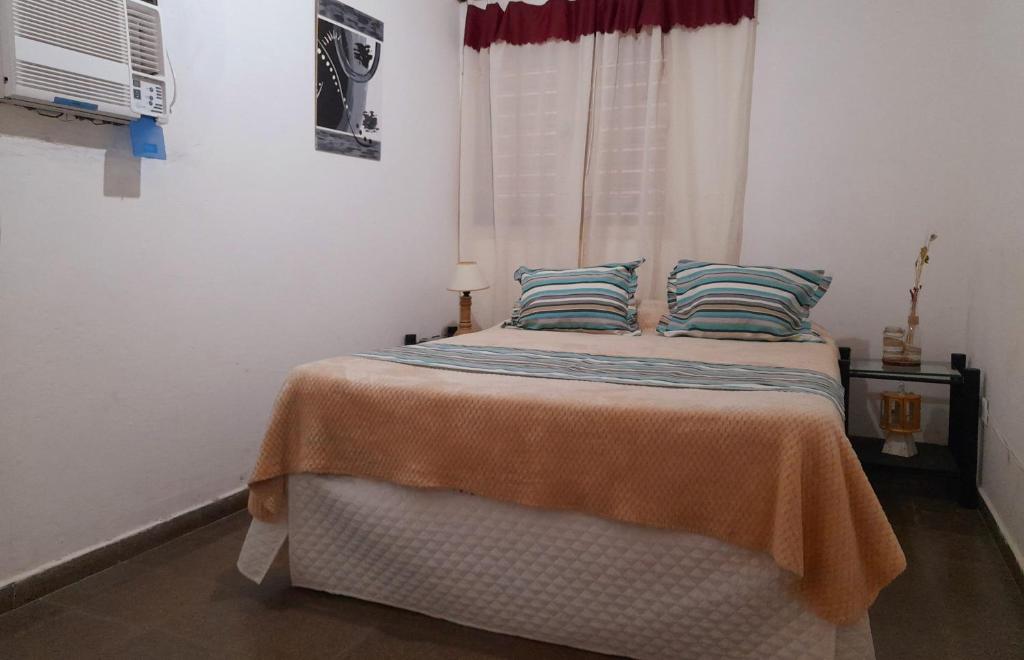 a bedroom with a bed with two pillows and a window at "Village" Amplia CASA boutique con parrilla y 2 garages in Corrientes