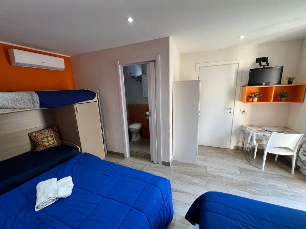 sypialnia z niebieskim łóżkiem i pokój ze stołem w obiekcie Verde Mare w Trapani