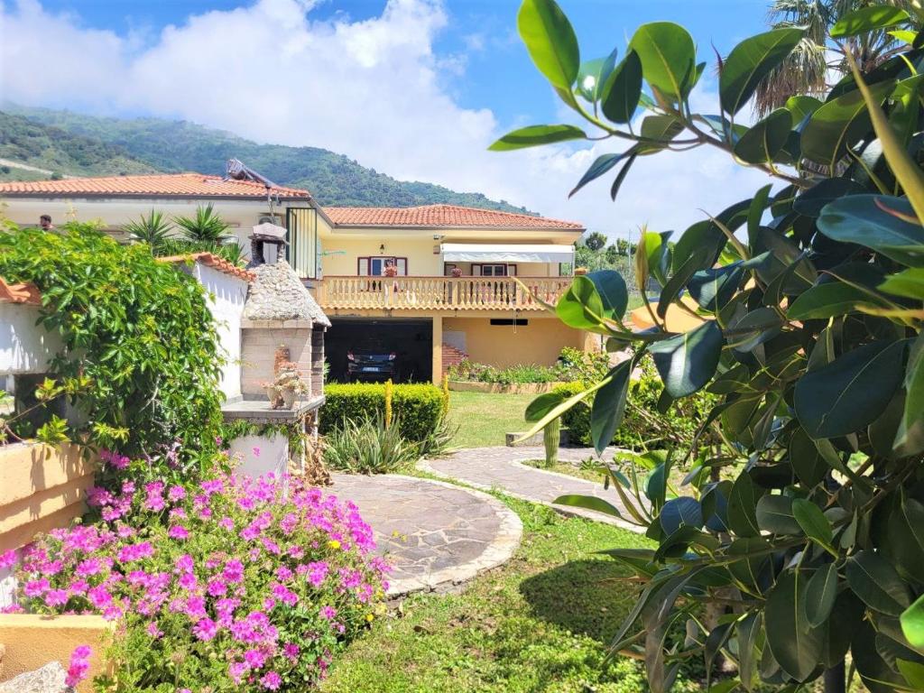 una casa con un jardín con flores rosas en Villa Selene "Jole" en Ioppolo