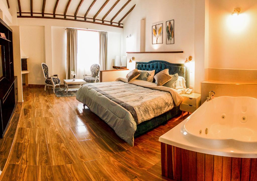 1 dormitorio con cama y bañera en Hotel Bahía Olivo Boutique & Spa, en Villa de Leyva