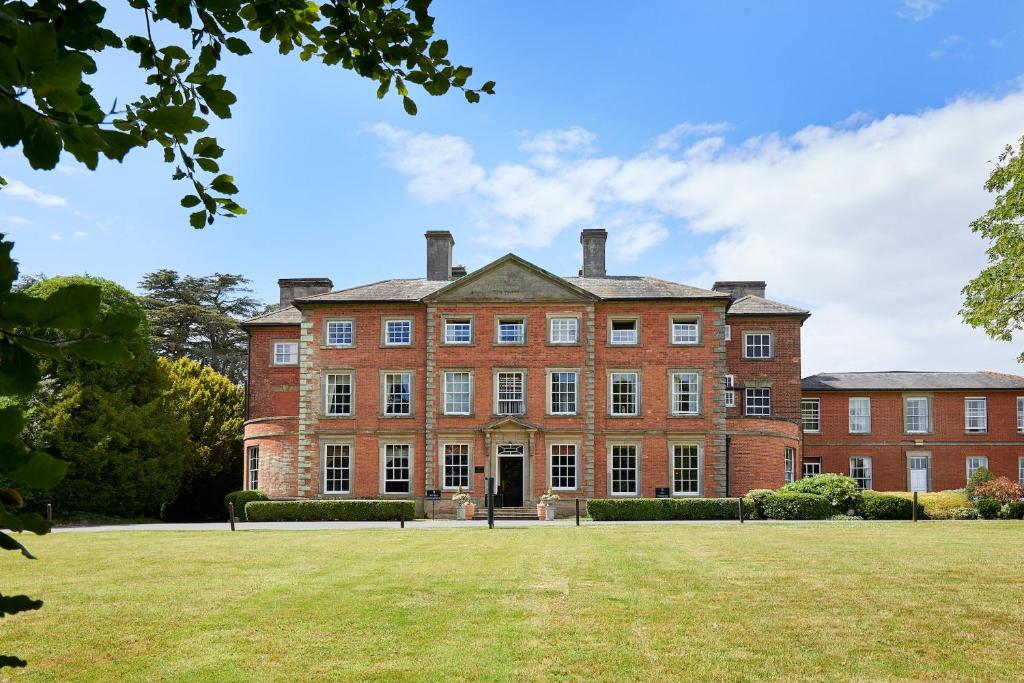 a large red brick building with a grass yard at Ansty Hall in Coventry