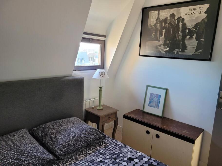 a small bedroom with a bed and a picture on the wall at Les Embruns - Plein ciel - appartement 3eme étage in Deauville