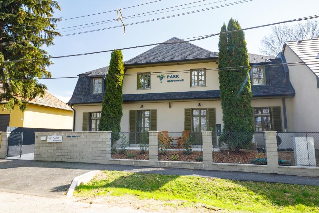 a house with a fence in front of it at PARK Apartmanok in Balatonszárszó