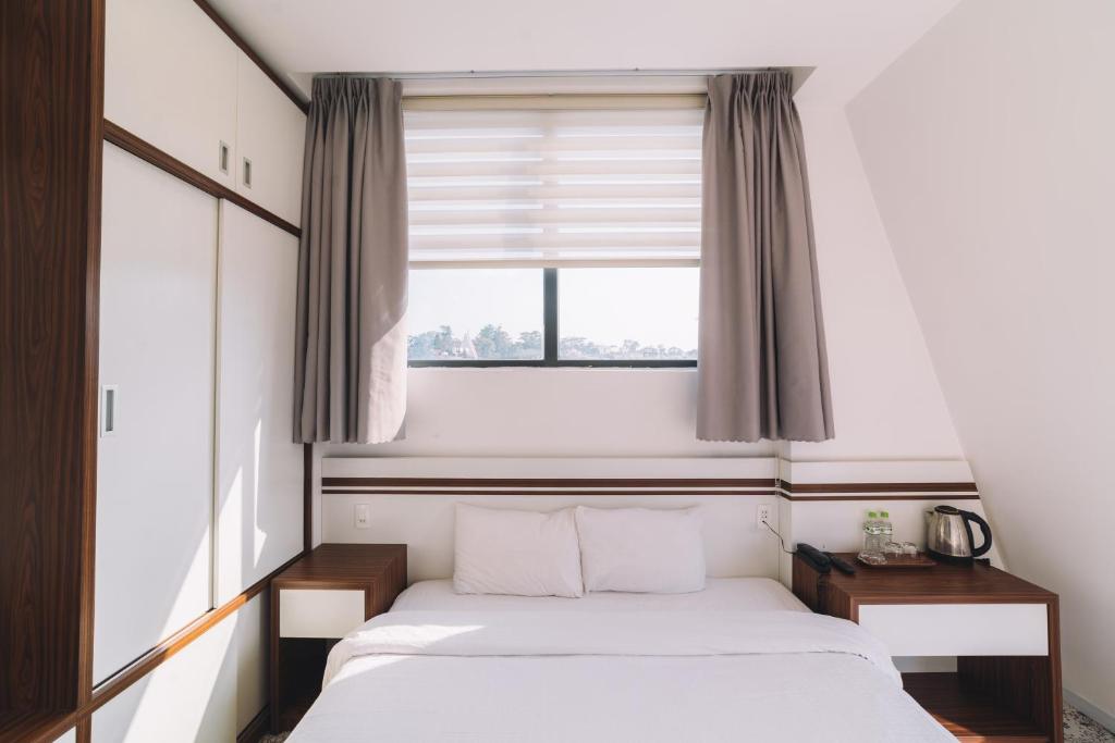Postel nebo postele na pokoji v ubytování Hạ Na Hotel Đà Lạt