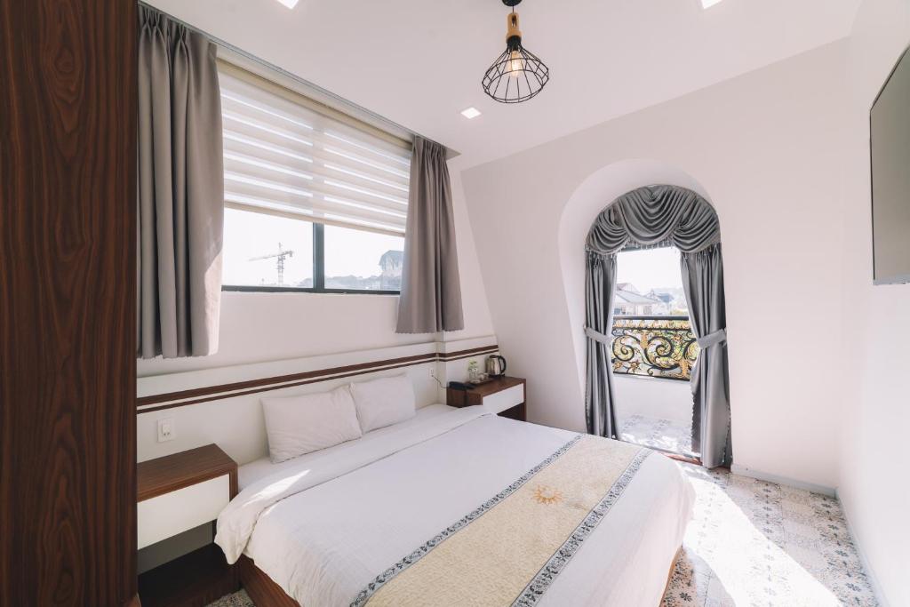 Postel nebo postele na pokoji v ubytování Hạ Na Hotel Đà Lạt